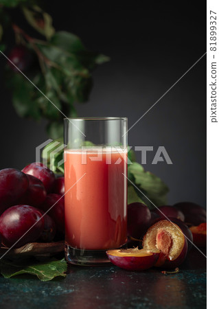 Plum juice and fresh purple plums. 81899327