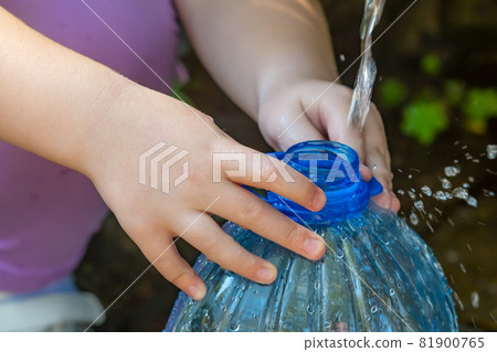 hands of a small child holding a plastic bottle hands of a small child holding a plastic bottle 81900765