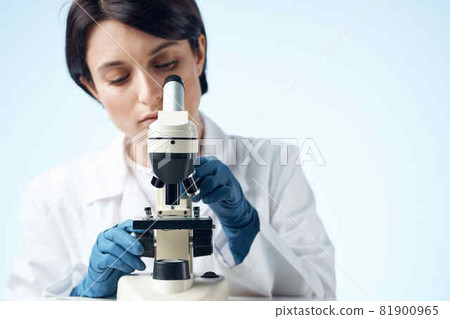 woman looking through a microscope laboratory research science experiment 81900965