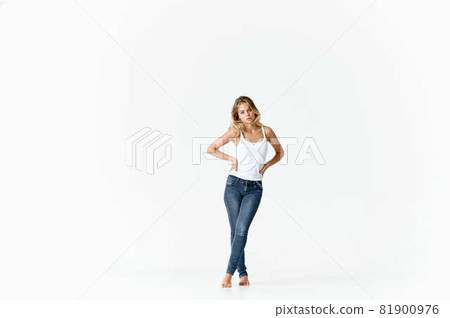 pretty blonde in jeans stands barefoot on the floor isolated background model pretty blonde in jeans stands barefoot on the floor isolated background model 81900976