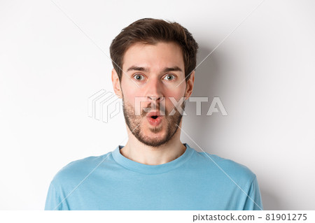 Close-up of surprised man face, saying wow and staring at camera amazed, standing on white background Close-up of surprised man face, saying wow and staring at camera amazed, standing on white background 81901275