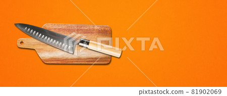 Traditional Japanese gyuto chief knife on a cutting board. Orange banner background Traditional Japanese gyuto chief knife on a cutting board. Orange banner background 81902069