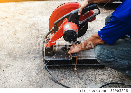Worker man cutting steel with a circular steel cutter. Worker man cutting steel with a circular steel cutter. 81903228
