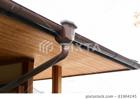 Rain gutter installed on the roof of the house Rain gutter installed on the roof of the house 81904245