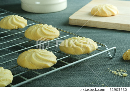 Close up image homemade butter cookies put on wire rack and a mug with wooden tray on the table. Close up image homemade butter cookies put on wire rack and a mug with wooden tray on the table. 81905880