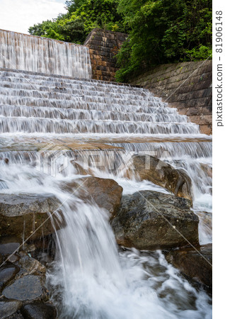 A cold summer river with high transparency flowing through a dam that blends in naturally A cold summer river with high transparency flowing through a dam that blends in naturally 81906148