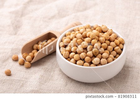 Chickpeas in white bowl with wood scoop, closeup Chickpeas in white bowl with wood scoop, closeup 81908311