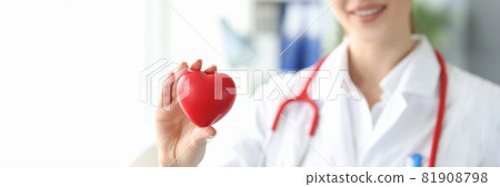 Woman cardiologist holds small red heart in her hand 81908798