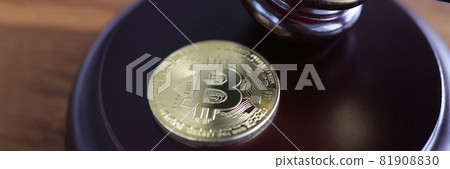 Bitcoin coin lies next to wooden judge gavel 81908830