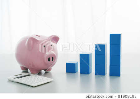 The image of systematically increasing savings. Graph of piggy bank, calculator and building blocks placed by the window. 81909195