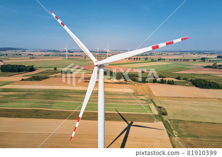 Windmill turbine in the field at summer day. Rotating wind generator 81910399