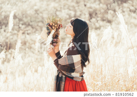 在日本蒲葦蔓延的高原上拿著花束的女人 81910562