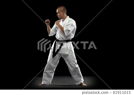 Full-length image of young sportsman practising karate isolated over black background Full-length image of young sportsman practising karate isolated over black background 81911015