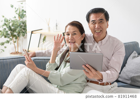 Senior couple smartphone tablet sofa Senior couple smartphone tablet sofa 81911468