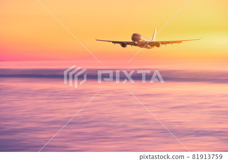 Airplane flying over tropical beach with smooth wave and sunset sky abstract background. 81913759
