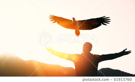 Man raise hand up on top of mountain and sunset sky with eagle bird fly abstract background. 81913760