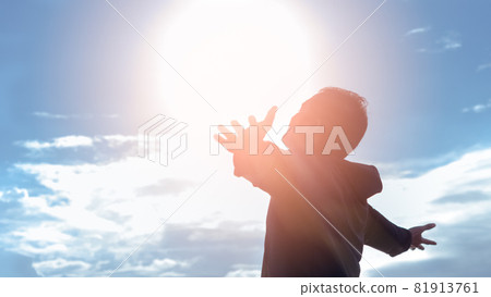 Freedom and feel good concept. Copy space of silhouette man rising hands on sunset sky background. 81913761