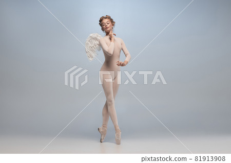 Full-length portrait of beautiful graceful ballerina dancing in image of angel with wings isolated on gray studio background. Art, motion, action, flexibility, inspiration concept. 81913908