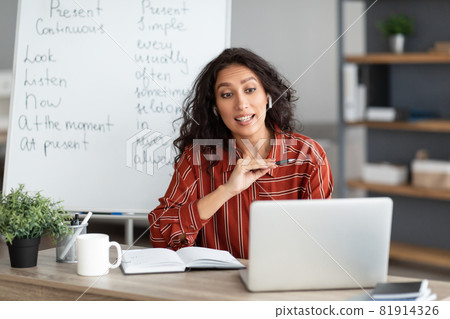 Serious English teacher having video call on laptop 81914326