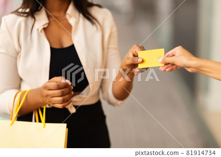 Unrecognizable black female giving credit card to seller 81914734