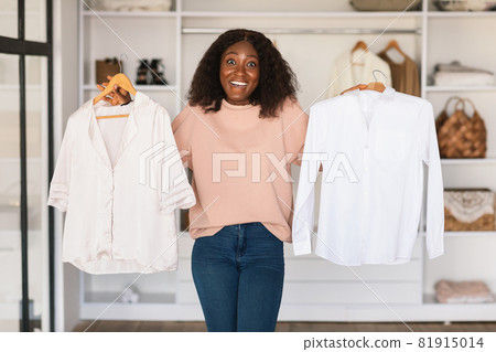 Black Lady Shopaholic Holding Shirts Choosing Buying Clothes In Store 81915014