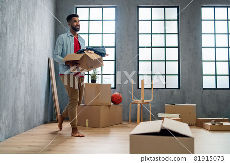Happy young man holding packing boxes moving home, new living concept. 81915073