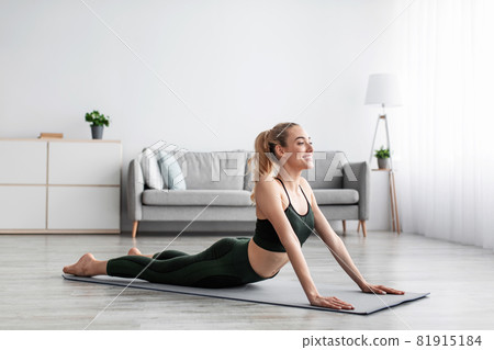 Cheerful glad caucasian pretty millennial blonde female practicing yoga, exercising alone at home Cheerful glad caucasian pretty millennial blonde female practicing yoga, exercising alone at home 81915184