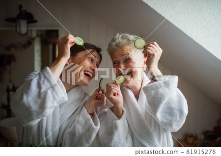 Happy senior mother in bathrobe with adult daughter indoors at home, selfcare concept. 81915278
