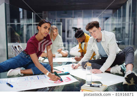 University students activists making banners for protest indoors, fighting for free education concept. University students activists making banners for protest indoors, fighting for free education concept. 81916871