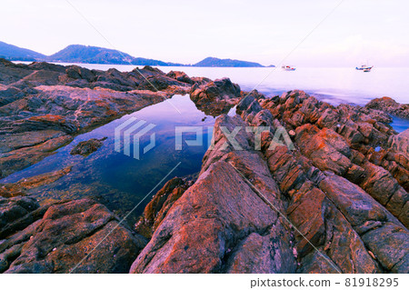 Colorful rocks and waves crashing on seashore Large colorful stones 81918295