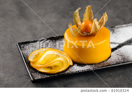 Yellow mousse dessert decorated with physalis 81918324