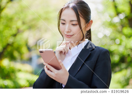 Recruit suit young woman looking at smartphone Recruit suit young woman looking at smartphone 81919626