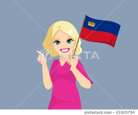 Happy young blonde curly haired white woman holding Liechtenstein flag and making pointing finger gesture 81920784