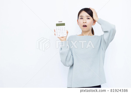 A woman in her thirties with a calculator 81924386