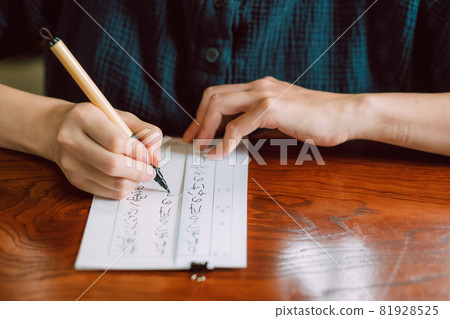 Japanese woman practicing penmanship, hard brush, brush pen Japanese woman practicing penmanship, hard brush, brush pen 81928525