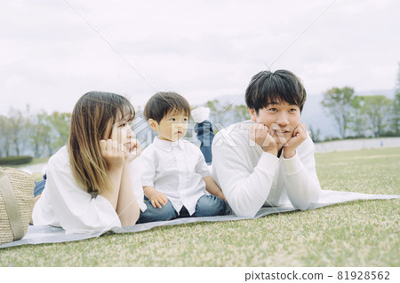 Parents and children having a picnic in the park (cheek canes) 81928562
