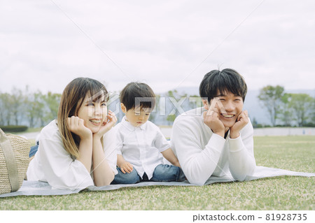Parents and children having a picnic in the park (cheek canes) 81928735