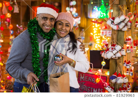 Portrait of couple with Christmas toys at fair outdoor Portrait of couple with Christmas toys at fair outdoor 81929963