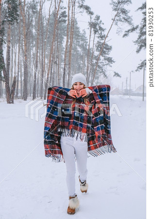 Dancing woman traveling among forest wearing hat and poncho, boho and wanderlust style. Winter is coming, first snowfall Dancing woman traveling among forest wearing hat and poncho, boho and wanderlust style. Winter is coming, first snowfall 81930253