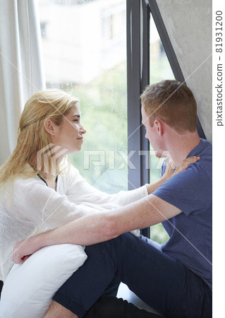 Couple Sitting on Window Sill 81931200