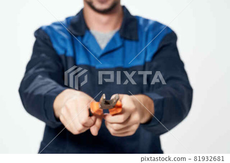 man in construction uniform with pliers in hands repair service 81932681