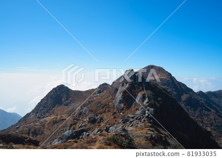 The natural scenery of the tawny mountains under the blue sky and white clouds. 81933035
