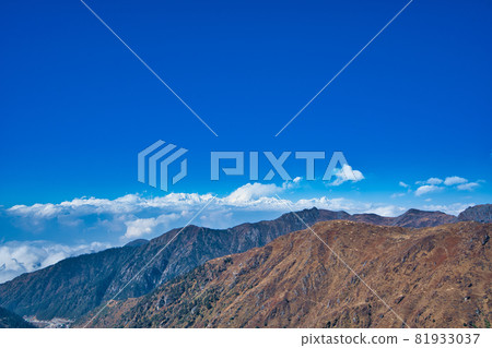 The natural scenery of the tawny mountains under the blue sky and white clouds. 81933037