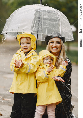Funny kids in rain boots playing in a rain park Funny kids in rain boots playing in a rain park 81933067