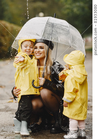 Funny kids in rain boots playing in a rain park Funny kids in rain boots playing in a rain park 81933080