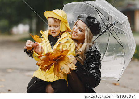 Funny kids in rain boots playing in a rain park Funny kids in rain boots playing in a rain park 81933084