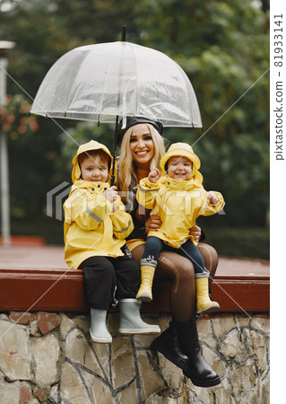 Funny kids in rain boots playing in a rain park Funny kids in rain boots playing in a rain park 81933141