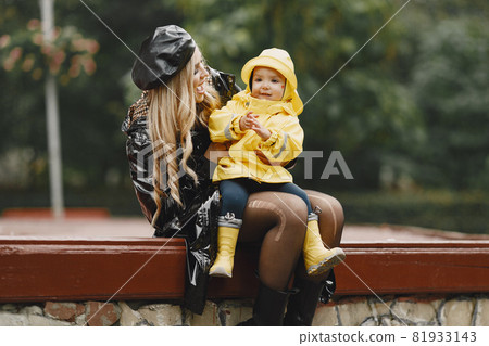 Funny kids in rain boots playing in a rain park Funny kids in rain boots playing in a rain park 81933143