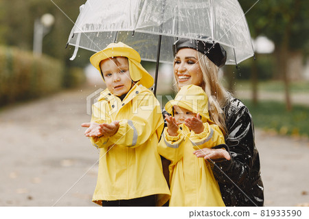 Funny kids in rain boots playing in a rain park Funny kids in rain boots playing in a rain park 81933590