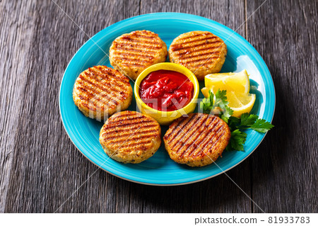 grilled fish burgers on a blue plate 81933783